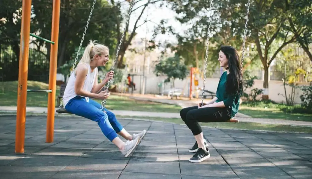 Two women laughing and swinging together, symbolizing Christian friendships and relationships.
