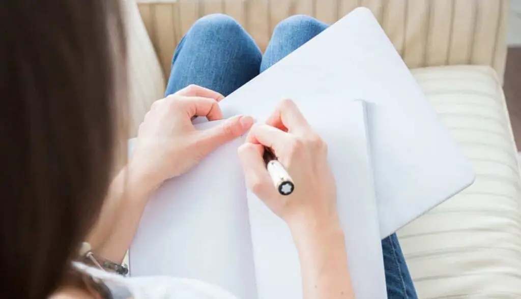 Writing faith story in notebook, sharing Christian faith and personal testimony