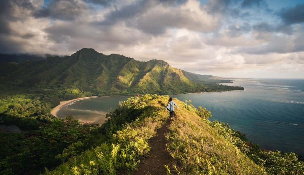 Person hiking along a path toward mountains and the sea, symbolizing a journey of faith and God's will.