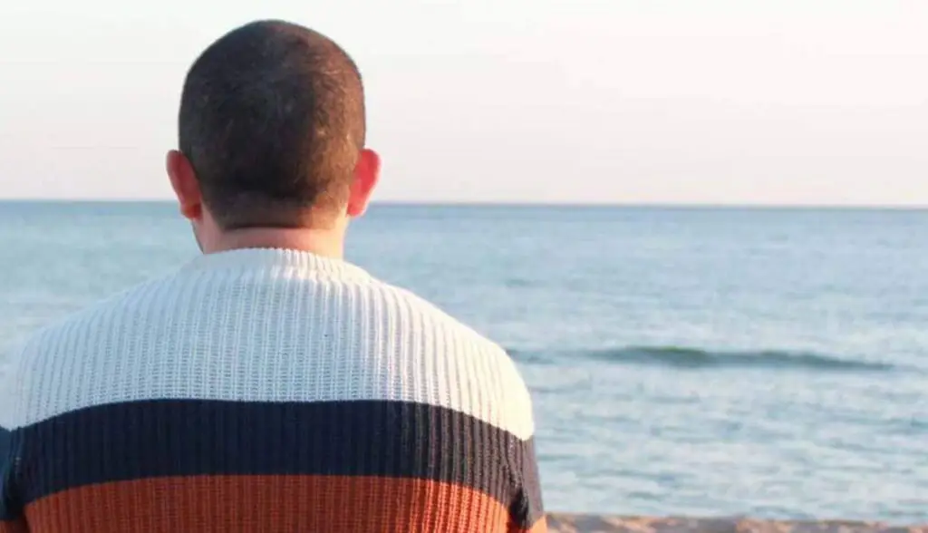 Man looking out at the ocean reflecting on mistakes and finding grace in Christian faith.