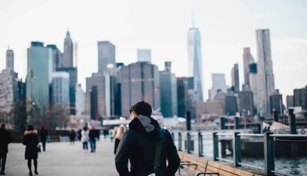 Man praying with cityscape in background, reflecting faith and relationships.