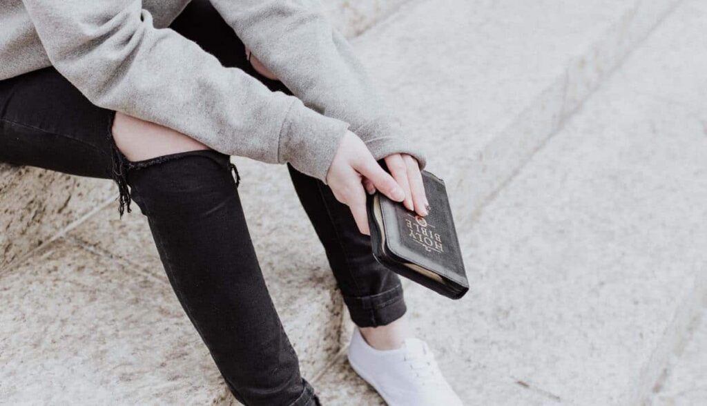 Person holding Bible, Christian faith and relationships.
