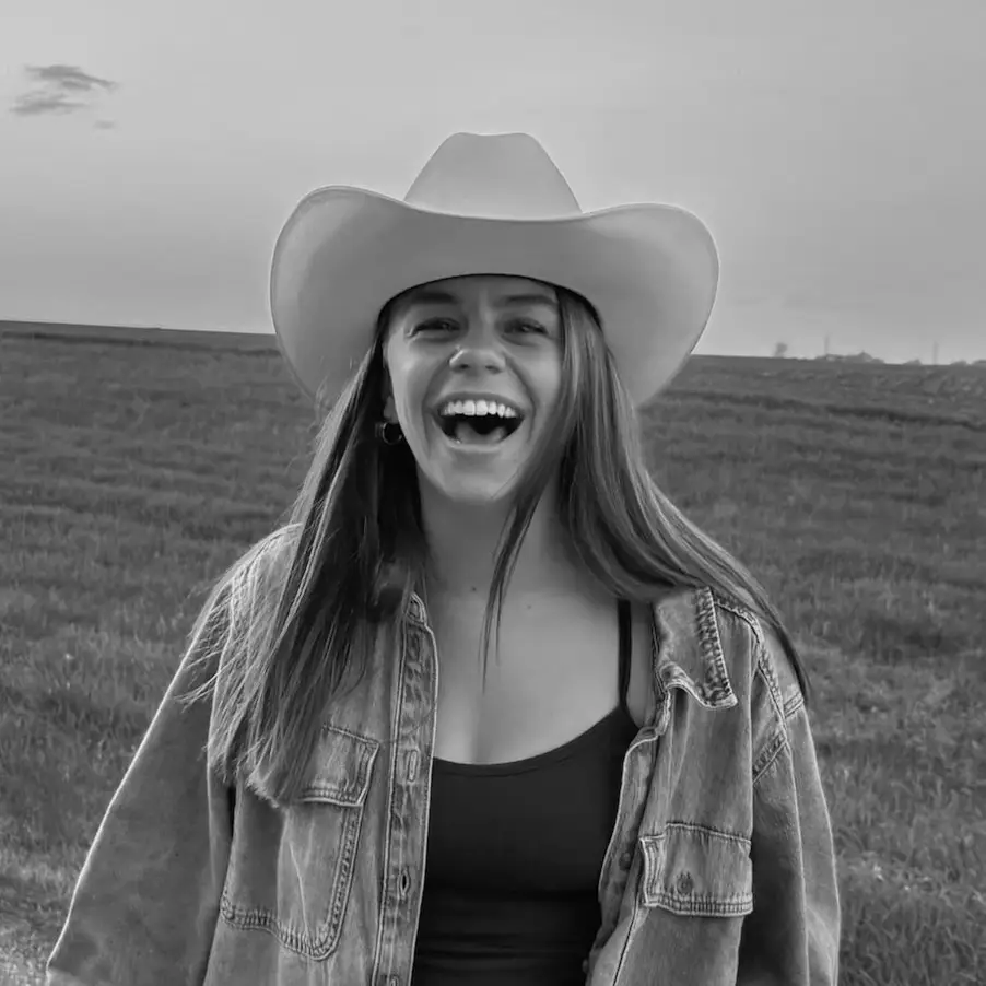 Kelsey Reynolds, podcast guest, smiling in a black and white portrait.