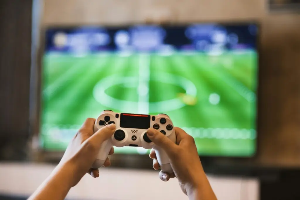 Hands holding PlayStation controller playing video game illustrating distractions and dwindling attention spans.