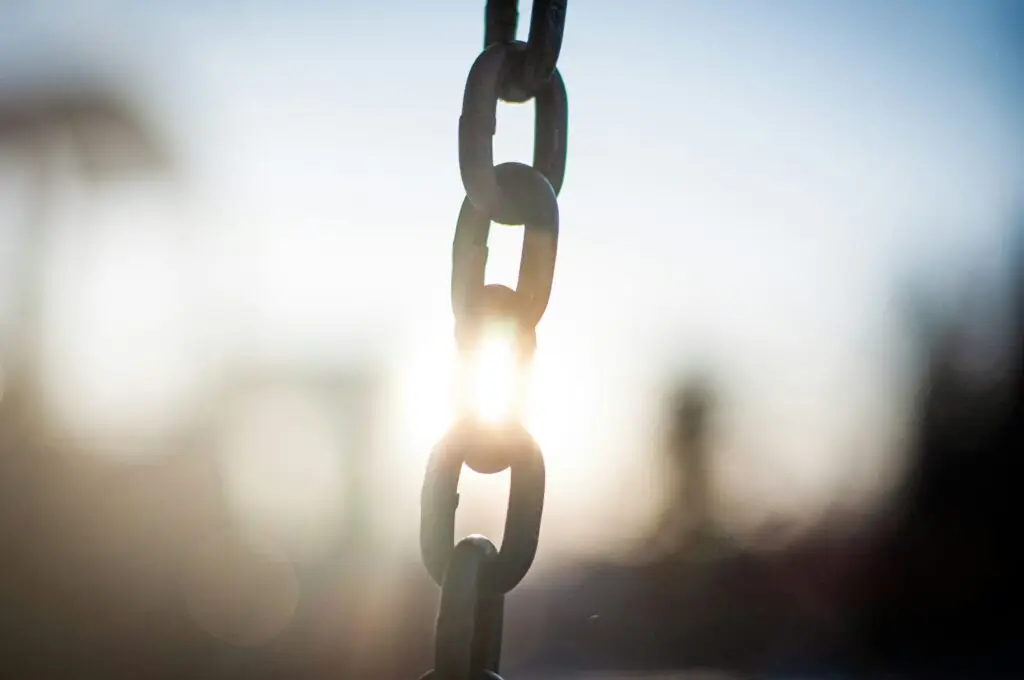 Chain links and sunlight symbolizing trust in God during difficult times.