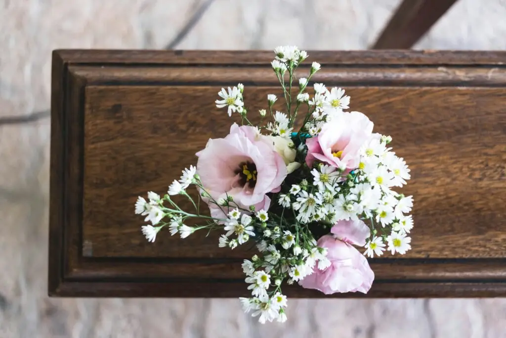 Flowers on wooden surface symbolizing remembrance and hope after loss.