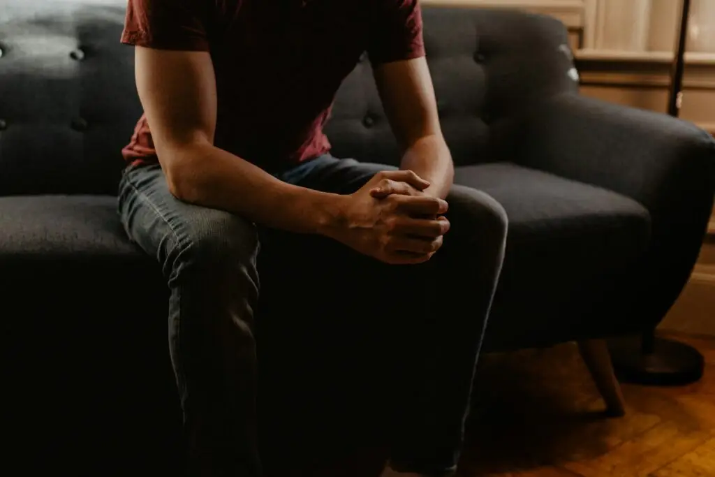 Man seated on sofa reflecting, illustrating Jesus as a wonderful counselor.